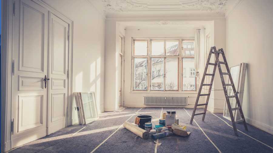 stock image of a vacant interior space with a ladder and paint tools in the middle of the room